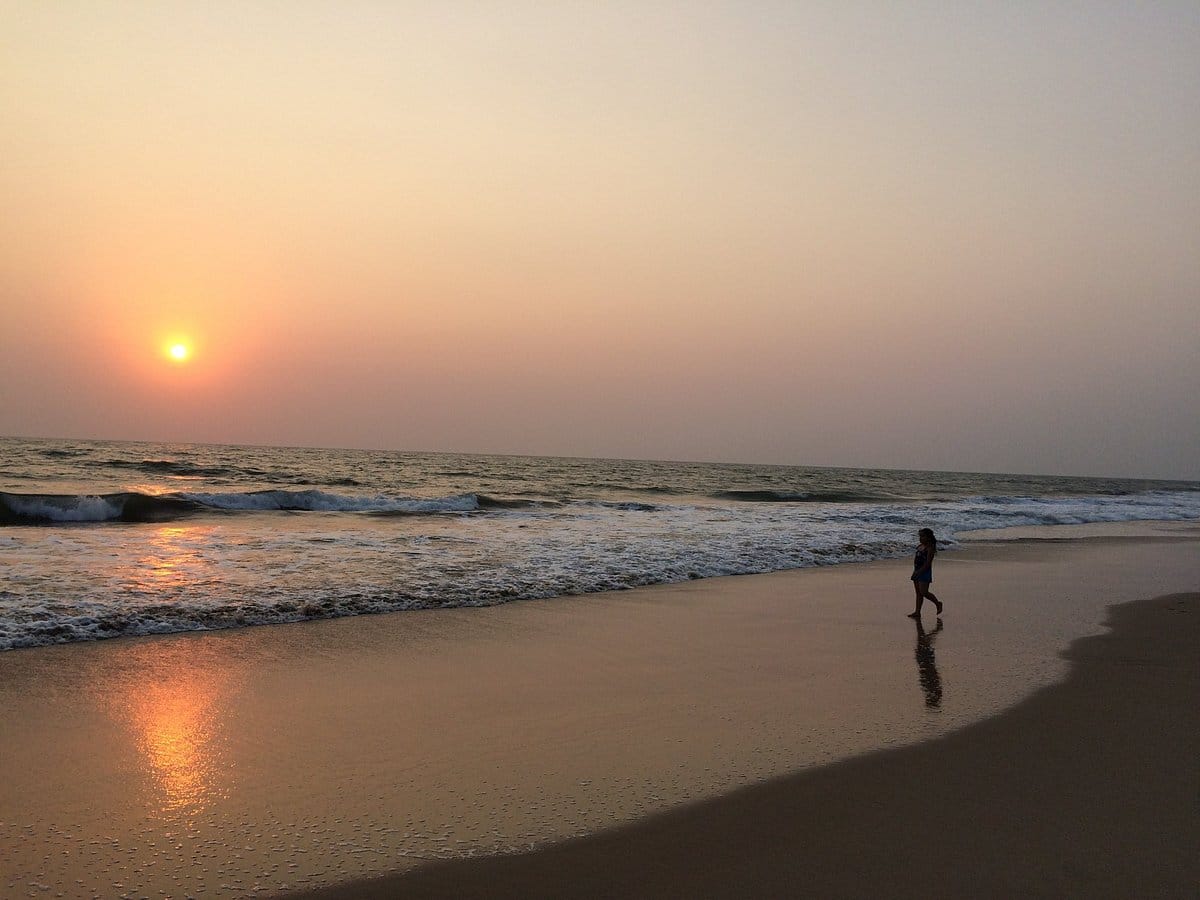 Mandvi beach coastline with soft sand, clear water, and traditional boats in background"